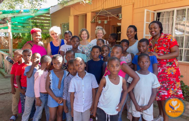 TA children pose for camera with international visitor & donor